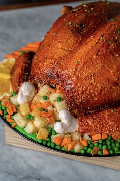 a roasted turkey with vegetables and stuffing on a platter