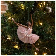 a ballerina ornament hanging from a christmas tree