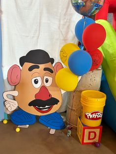 there is a giant balloon with a face on it next to other balloons and toys