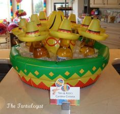 an inflatable boat filled with bottles of beer and sombreros on top of a counter