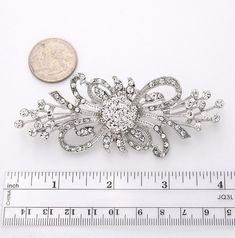 "Beautiful rhinestone silver brooch jewelry embellishment, which can be used for your DIY project - Vintage brooch bouquet, bridal gown sash, necklace, cake decorations, event decor, crafts, scrap booking, jewelry gift and much more. Size: 3 3/4\"W x 1 1/2\"H Stones color: Crystal clear Metal: Silver plated This crystal silver brooch can be ordered with pin in the back to add to wedding gown or dress sash, to wire into brooch bouquet, or any number of other craft projects; or without the pin as Elegant Silver Crystal Pins, Silver Crystal Brooch For Anniversary, Silver Crystal Brooches For Anniversary, Silver Crystal Anniversary Brooches, Rhinestone Pins For Wedding, Wedding Pins With Rhinestones, Silver Rhinestone Brooches For Wedding, Silver Wedding Brooches With Rhinestones, Silver Crystal Brooch Pin