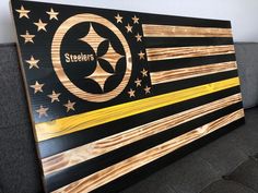 the pittsburgh steeles flag is made out of wood and has gold stars on it