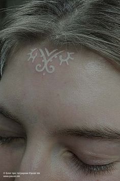 a man with a white tattoo on his forehead