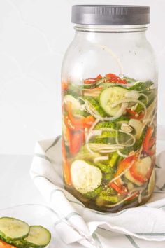 a mason jar filled with vegetables and sliced cucumbers