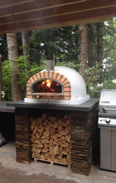 an outdoor pizza oven with firewood stacked in it