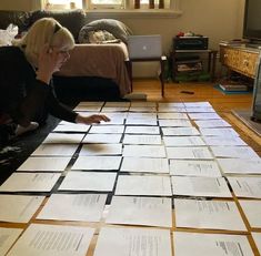 a woman sitting on the floor surrounded by papers