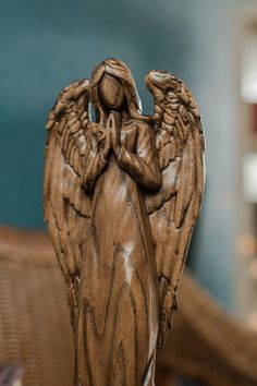 an angel statue sitting on top of a wooden table