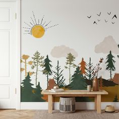 a wall with trees and birds painted on it in front of a door, near a table