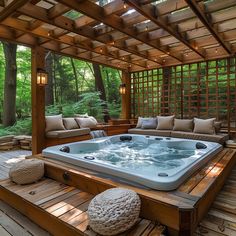 a large hot tub sitting on top of a wooden deck next to a couch and table