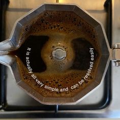 a metal object with words on it sitting in front of a stove top burner