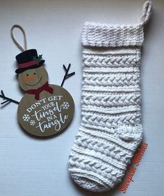 a christmas ornament next to a knitted sock with a tag that says, don't get your tiny snowman today