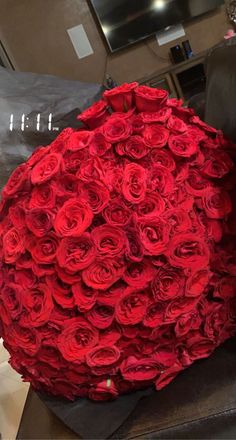 a large bouquet of red roses sitting on top of a chair