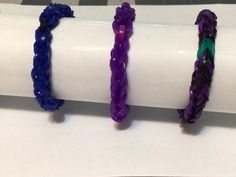 three different colored bracelets sitting on top of a white table next to each other