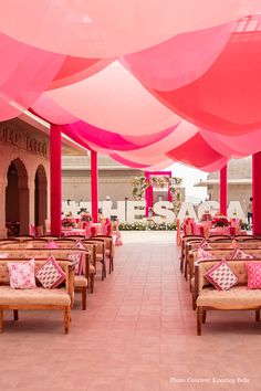 the inside of a restaurant with pink and white decor on it's walls, tables and benches