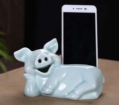 a cell phone sitting next to a ceramic pig