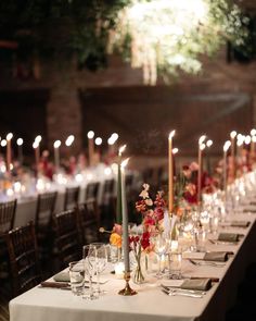 a long table is set with candles and flowers for an elegant dinner or party event