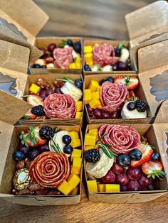 four boxes filled with different types of food on top of a wooden table next to each other