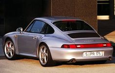 a silver sports car parked in front of a building