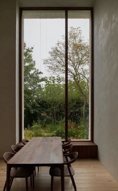 a wooden table sitting in front of a large window