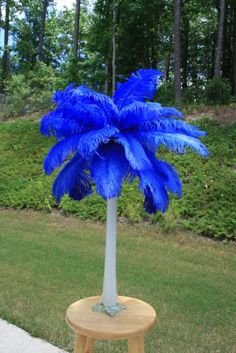 a small blue tree sitting on top of a wooden table next to a lush green park