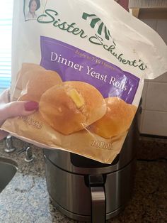 a bag of dinner yeast rolls being held in front of an electric blender