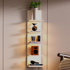 a white shelf filled with books next to a chair and potted plant on top of it