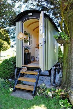 a tiny house with stairs leading up to the front door and side entrance, on wheels