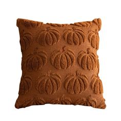 a brown pillow with an intricate design on the front and back, sitting on a white background