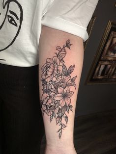 a black and white flower tattoo on the arm