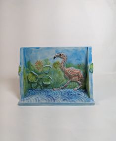 a ceramic tray with a bird and waterlilies on it