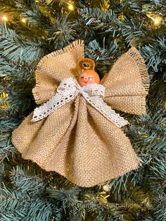 an angel ornament hanging on a christmas tree