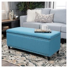 a blue ottoman sitting on top of a rug