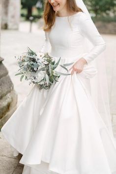 a woman in a wedding dress holding a bouquet