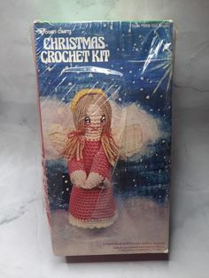 a christmas crochet kit with an angel doll in it's box on a white surface