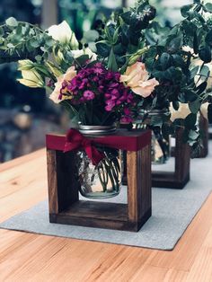 three vases filled with flowers on top of a wooden table