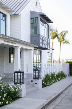 a white house with flowers in the front yard