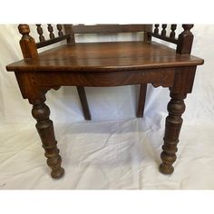 an old wooden chair sitting on top of a white sheet