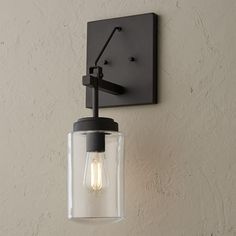 a light that is on the wall next to a white wall with a black frame