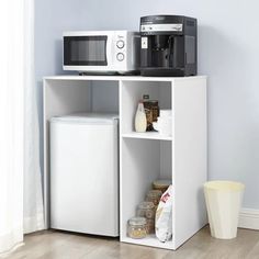 a microwave oven sitting on top of a white shelf