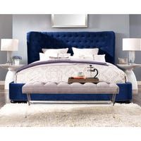 a bed with a blue headboard and foot board on top of white rugs