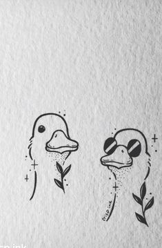 two ducks with faces drawn on paper