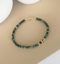 This dainty emerald bracelet is available in 14k gold filled or sterling silver.  It's beaded with off center smooth metal bead and finished with a lobster claw clasp. This bracelet looks great on it's own and pairs well with other bracelets for a pop of color. A great handmade birthstone jewelry gift for a May birthday girl or a special girl on any occasion.   Please select your wrist size and metal preference from the drop down menu at check out.  The emerald rondelles and smooth metal beads a Emerald Bead Bracelet, Chinese Bracelet, Homemade Bracelets, Green Beaded Bracelets, May Birthday, Bracelets Design, Emerald Bracelet, Metal Bead, Gold Armband