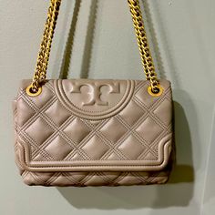 Medium Sized Bag That Can Be Worn On The Shoulder Or Even Crossbody. Please See Pics For Signs Of Wear. They Do Not Show Very Well On This Color But There Is Wear On The Edge Of The Flap Especially Corners As Well As Some On The Chain And One Spot In Particular Shown In Photos. Inside Is Very Clean And Comes With The Dust Bag. This Is A Very Beautiful Bag With Soft Quilted Leather In A Nice Neutral Grey That Pulls A Little Taupe. Magnetic Closure Gold Hardware Beautiful Gray Leather Dust Bag Inc Gray Rectangular Shoulder Bag With Gold-tone Hardware, Gray Leather Bag With Gold-tone Hardware, Gray Shoulder Bag With Silver-tone Hardware, Beige Leather Shoulder Bag With Silver-tone Hardware, Tan Crossbody Shoulder Bag With Silver-tone Hardware, Medium Sized Bags, Gray Leather, Tory Burch Bag, Quilted Leather