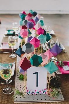 the table is decorated with colorful umbrellas and place cards