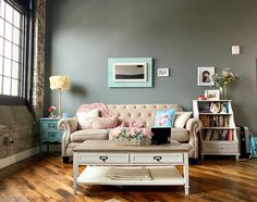 a living room with a couch, coffee table and bookshelf on the wall