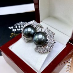 We are presenting you a HUGE pair of STUDS, Genuine, BLACK, Tahiti, South Sea Pearls, extremely FINE AA+, LUSTROUS and Rare! Accenting the 2 pearls are 54 pieces of E/VS Natural diamonds, weighting a total of 1.50 carats. Set in fabulously designed 18K solid white gold earrings. ONLY ONE ITEM AVAILABLE!! NO DUPLICATES!! WHAT YOU SEE IN THE PICTURES IS WHAT YOU WILL GET SOLIDLY HANDCRAFTED EARRINGS! SUGGESTED RETAIL VALUE: $10,880 PEARLS: Size: 15 mm Shape: Near Round Color: Grey/Black with a hin Formal Black Tahitian Pearl Earrings, Luxury Black Tahitian Pearl Earrings, Golden South Sea Pearls, Vs Diamond, White Gold Earrings, South Sea Pearls, Sea Pearls, White Gold Engagement Rings, Handcrafted Earrings