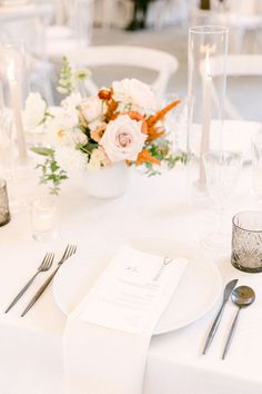 the table is set with silverware and flowers