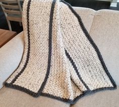 a crocheted blanket sitting on top of a couch