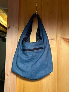 a blue purse hanging on a wooden wall