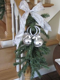 a christmas tree with ornaments hanging from it's sides on the banisters